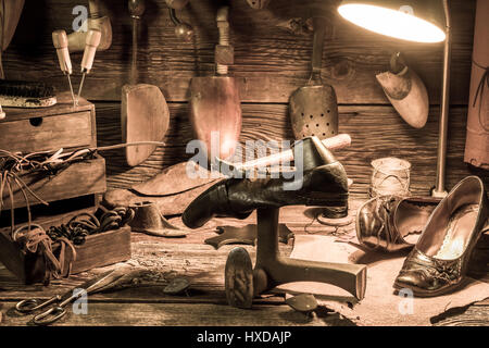 Vintage Schuhmacher Arbeitsplatz Werkzeuge, Schuhe mit Schnürsenkeln Stockfoto