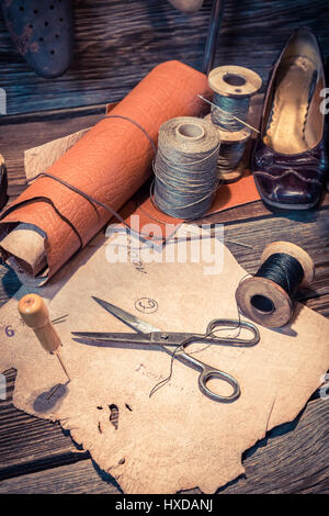 Vintage Schuster Arbeitsplatz mit Werkzeugen, Schuhe und Leder Stockfoto