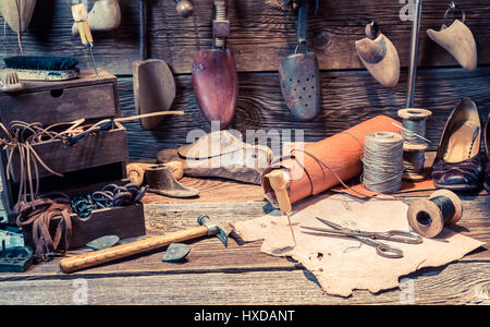 Vintage Schuster Arbeitsplatz mit Werkzeugen, Leder und Schuhe Stockfoto