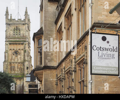 eine enge Schuss von Architektur in Cirencester mit St. Johannes der Täufer und Cotswold Leben hängen Shop unterzeichnen im Vordergrund, UK Stockfoto