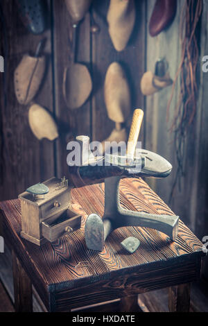 Alten Schuster-Arbeitsplatz mit Schuhe, Schnürsenkel und Werkzeuge Stockfoto