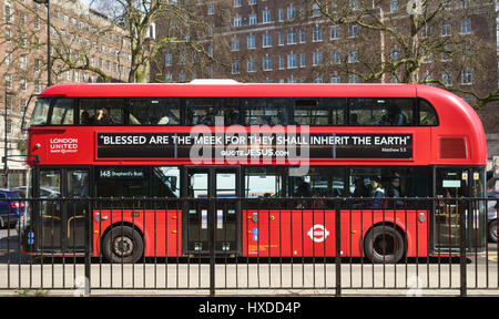 London, UK. Eines der rot neue Routemaster-Busse 2012 eingeführt. Es trägt eine biblische Plakat "Selig sind die Sanftmütigen, denn sie werden die Erde erben Stockfoto