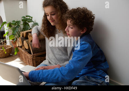 Porträt eines netten jungen und Mädchen mit Laptop zusammen zu Hause Stockfoto