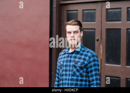 Hipster draußen posiert für die Kamera mit einem Modestil vorwärts und einen modernen Menschen auftritt. Stockfoto