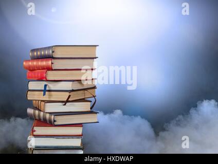 Digital Composite Bücher gestapelt durch atmosphärische Wolken Stockfoto