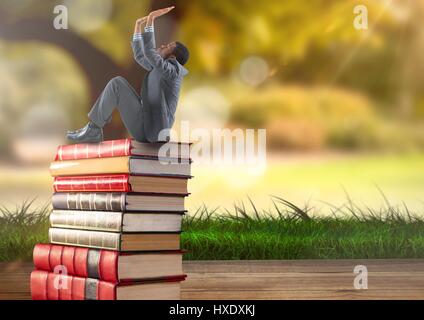 Digitalen Verbund aus Geschäftsmann sitzt auf Bücher gestapelt Grün Natur Stockfoto
