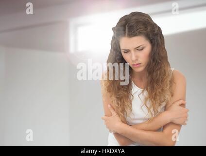 Digitalen Verbund der traurige junge Frau hält sich gegen Fensterlicht Stockfoto