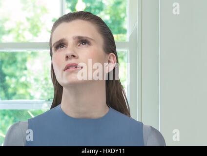 Digital Composite sorgen Frauen suchen Hoffnung gegen sonnigen Fenster Stockfoto