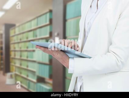 Digital Composite Womans Tabletten halten Tablet in Bibliothek Stockfoto