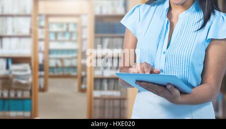 Digital Composite Frau auf Tablet in Bibliothek Stockfoto