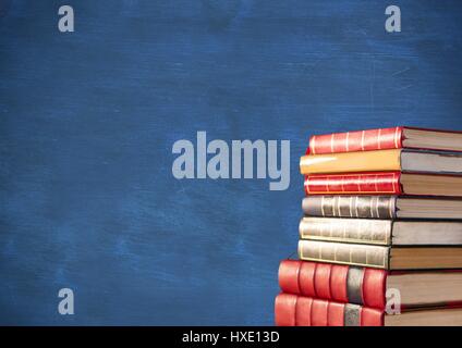 Digitalen Verbund aus Stapel Bücher gegen blaue Tafel Stockfoto