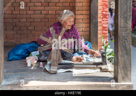 Bhaktapur, Nepal - vom 20. März 2015: alte Frau Spinnen von Wolle Stockfoto
