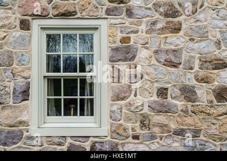 Stein Haus in historischen kolonialen Fenster mit einer Kerze im Inneren Stockfoto