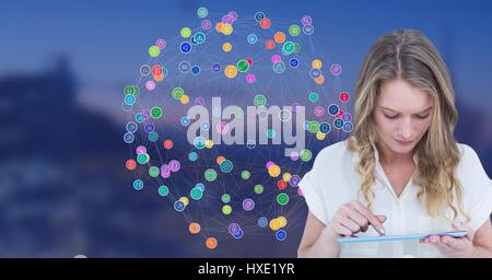 Digital Composite Frau berühren Tablet gegen nächtliche Stadt mit Steckern Stockfoto
