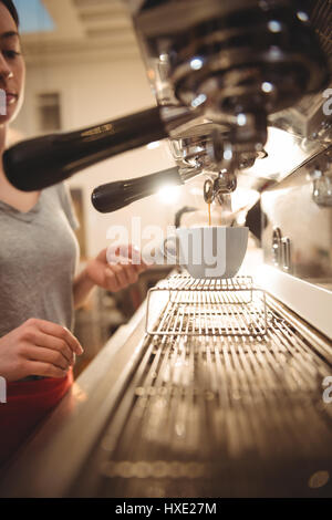 Zugeschnittenes Bild des weiblichen Barista machen Kaffee Espresso-Automaten im café Stockfoto