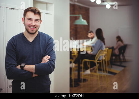 Männliche executive stehend mit Arme gekreuzt im Büro Stockfoto