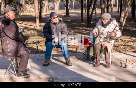 Ältere chinesische Mann spielt die zwei saitige chinesische Geige oder Erhu an einem Wintertag im Tempel des Himmels Park in Peking. Stockfoto