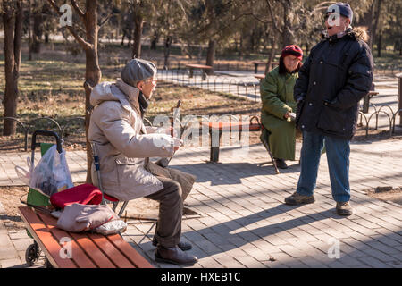 Ältere chinesische Mann spielt die zwei saitige chinesische Geige oder Erhu an einem Wintertag im Tempel des Himmels Park in Peking. Stockfoto