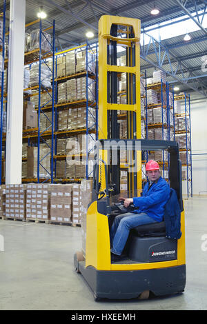 St. Petersburg, Russland - 21. November 2008: Der Fahrer eines Gabelstaplers gelb bedient, in Lagerhallen, sitzen am Arbeitsplatz. Stockfoto