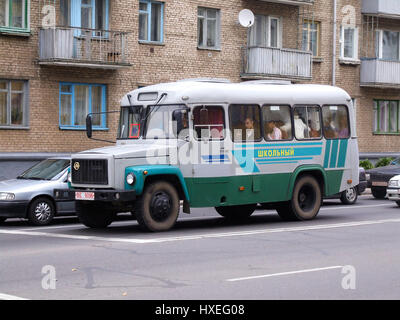 Öffentlicher Bus auf der Straße in Wizebsk, Weißrussland.  Hinten ist ein Regierung-Mehrfamilienhaus. Stockfoto