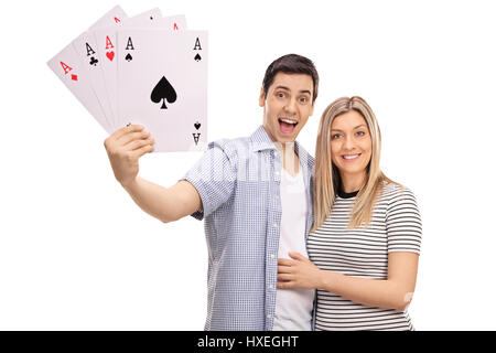 Fröhliches junges Paar mit vier Asse Spielkarten isoliert auf weißem Hintergrund Stockfoto