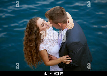 Junge liebende Paar auf einem Spaziergang am See am Tag ihrer Hochzeit Stockfoto