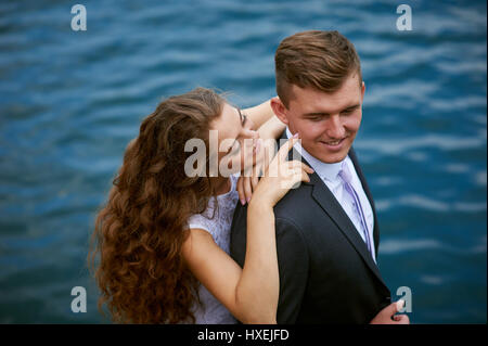 Junge liebende Paar auf einem Spaziergang am See am Tag ihrer Hochzeit Stockfoto