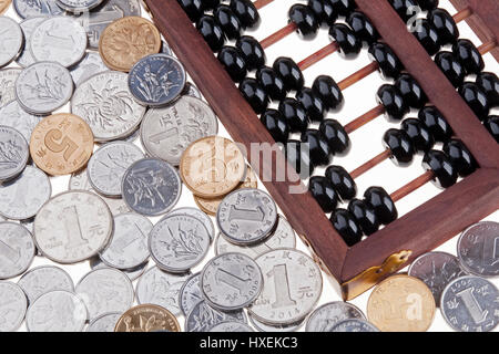 Nahaufnahme von einem alten hölzernen chinesischen Abakus und chinesischen Münzen Stockfoto