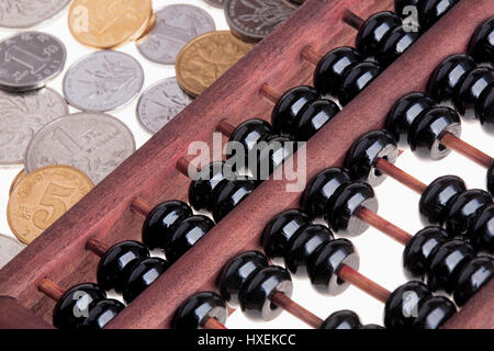 Nahaufnahme von einem alten hölzernen chinesischen Abakus und chinesischen Münzen Stockfoto