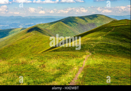 gewundenen Weg durch die großen Wiesen am Hang des Bergrückens Karpaten Stockfoto