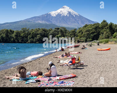 Strand im Dorf Ensenada, See Lago Llanquihue, Blick Richtung schneebedeckter Vulkan Osorno, Sommer, Menschen am Strand, Sonnenbaden, Schwimmen, kay Stockfoto