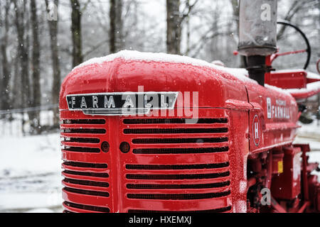 Ein rot Farmall Traktor im Schnee auf einer kleinen Farm in New England Stockfoto