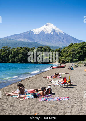 Strand im Dorf Ensenada, See Lago Llanquihue, Blick Richtung schneebedeckter Vulkan Osorno, Sommer, Menschen am Strand, Sonnenbaden, Schwimmen, kay Stockfoto