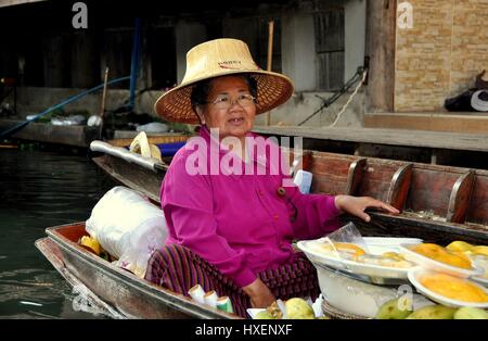 Damnoen Saduak, Thailand - 9. Januar 2010: Frau köstlich frische tropische Mangos von ihr Boot zu verkaufen, wie sie an einem Kanal an den schwimmenden Paddel Stockfoto