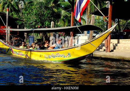 Damnoen Saduak, Thailand - 9. Januar 2010: Ein überdachtes lange Boot bringt Touristen für eine Fahrt durch die Kanäle von den berühmten schwimmenden Markt * Stockfoto