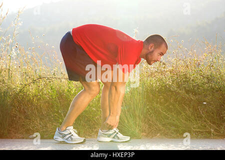 Seite Porträt eines Sport seinen Schuh vor der Ausführung der Übung anpassen Stockfoto