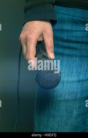 Junge Sängerin in Jeans mit dynamisches Mikrofon. Stockfoto