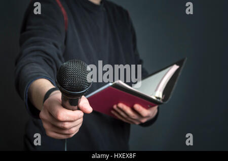 Journalistin bei Pressekonferenz mit Mikrofon und Notizen. Selektiven Fokus. Stockfoto