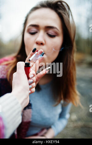 Hand des Mädchens mit Zigarettenanzünder. Aufhören Sie zu rauchen gesellschaftliches Problem. Freunde Rauchen. Stockfoto