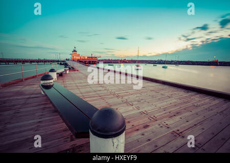 St. Kilda Pier in der Abenddämmerung mit Booten im Hafen und Pavillon in der Ferne. Melbourne, Australien Stockfoto