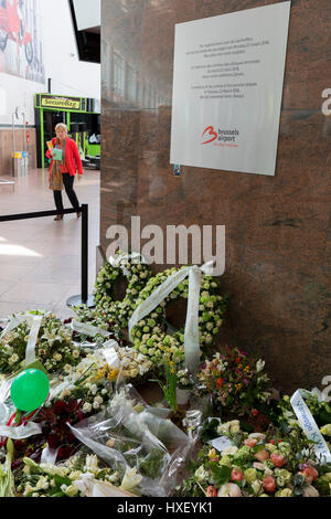 Blüten bilden das Denkmal für die Fahrgäste und Reisende, getötet in Flughafen Brüssel-Zaventem, ein Jahr später, am 26. März 2017, am Flughafen Brüssel-Zaventem, Belgien. Am Morgen des 22. März 2016, traten drei koordinierte Selbstmordattentate in Belgien: zwei am Brüsseler Flughafen Zaventem und in Maalbeek Metro-Station im Zentrum von Brüssel. Zweiunddreißig Zivilisten und drei Täter wurden getötet und mehr als 300 Personen wurden verletzt. Stockfoto