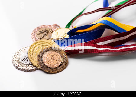 Vielzahl von Sportmedaillen auf weiß Stockfoto