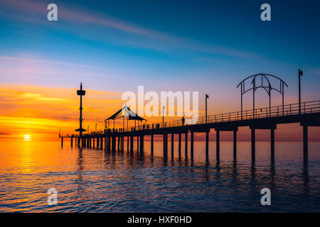 Menschen zu Fuß entlang der Brighton Pier bei Sonnenuntergang. South Australia Stockfoto