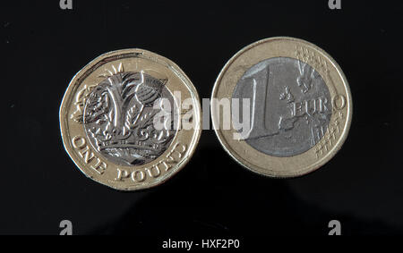 Eine neue 12-seitigen £1 Münze (links) neben einer 1-Euro-Münze in Liverpool als neues Pfund Münze eingegeben Rundschreiben - mit frühen Kinderkrankheiten am Münzautomaten im Land erwartet. Stockfoto