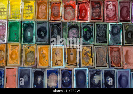 Box mit Wasserfarben und Pinsel auf Holzuntergrund Stockfoto