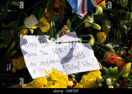 Hinweis auf die Blumen unter Bezugnahme auf PC Keith Palmer und trafen Polizeibeamte: "Warum sie nicht geben Sie Wepen selbst & uns zu verteidigen. Warum? Warum? Warum? " Stockfoto