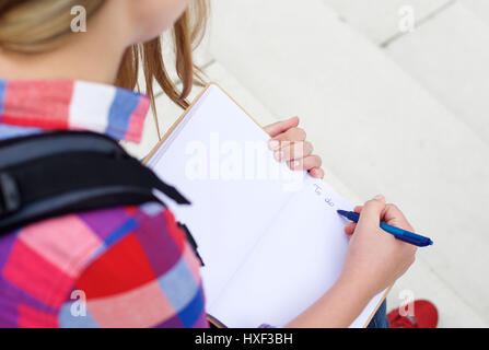 Porträt von oben von einem Mädchen schreiben eine to do-Liste in Buch Stockfoto