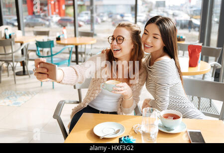 Zwei Freundinnen tun Selfie im café Stockfoto