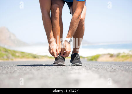 Niedrige Teil der Athleten tragen von Schuhen unterwegs gegen Himmel Stockfoto