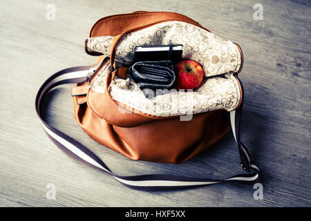 in Frau Lederhandtasche auf dem Holzboden Stockfoto